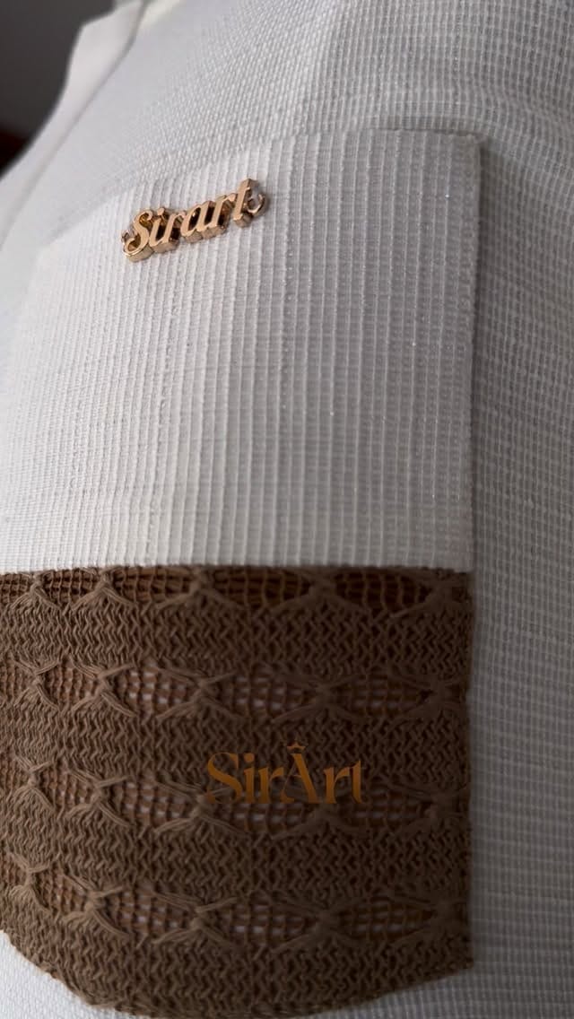 Cream waffle-weave fabric with brown crochet trim and a SirArt pin, close-up