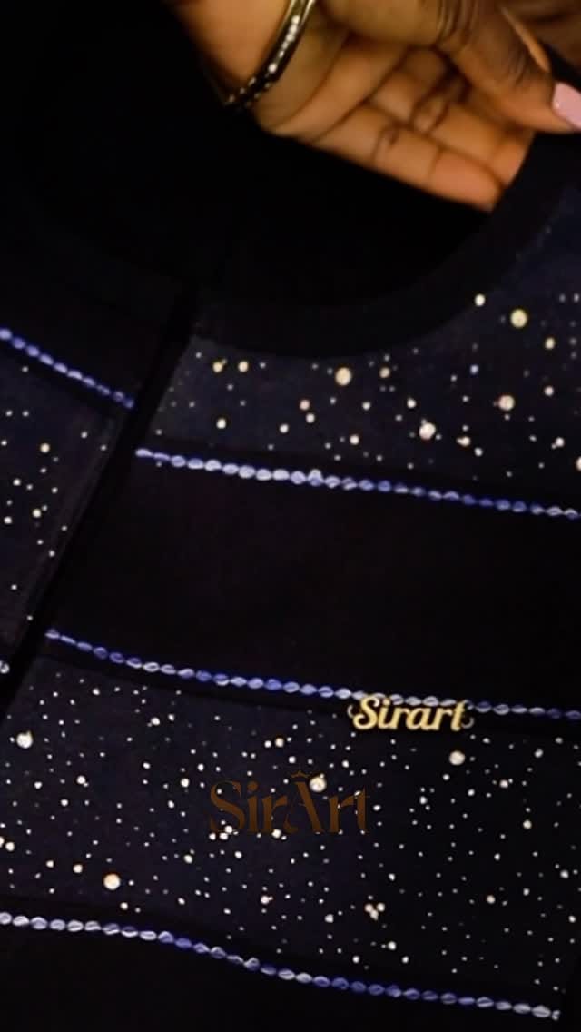 Midnight-navy fabric embellished with rows of crystals, macro detail