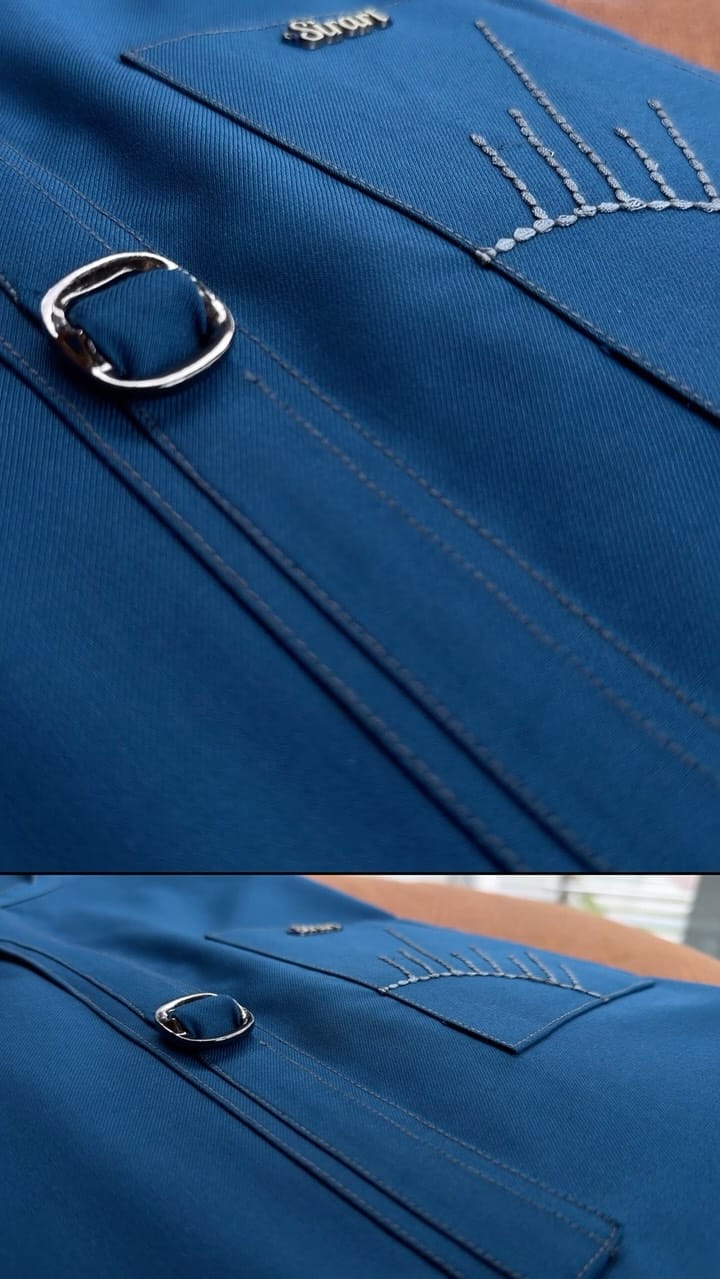 Cobalt-blue kaftan fabric with silver ring zip pull and stitch detailing, close-up