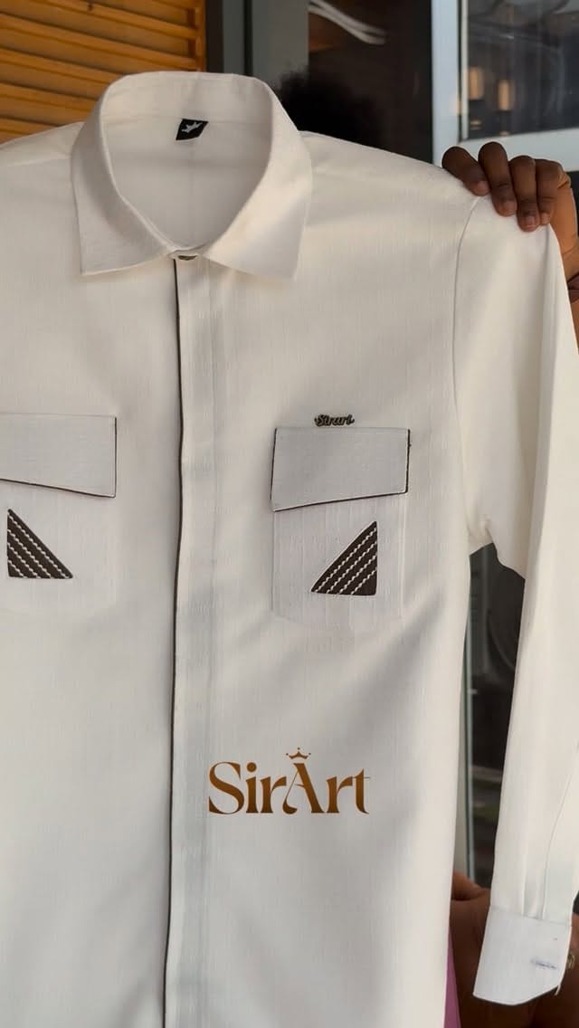 Crisp cream kaftan shirt with double chest pockets and embroidered accents on a hanger