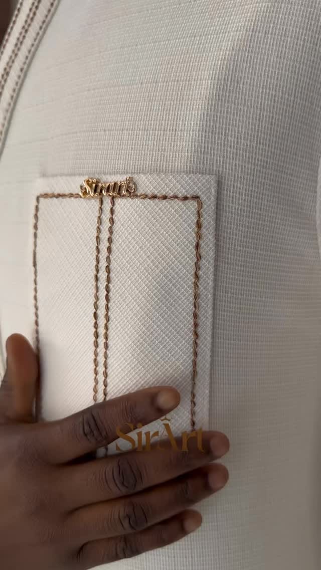 Hand resting on white handwoven fabric with a gold chain draped across it